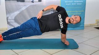 Immer dabei lächeln: De Ketscher Fitnesscoach im Seitstütz – die erste Übung in dieser Einheit.
