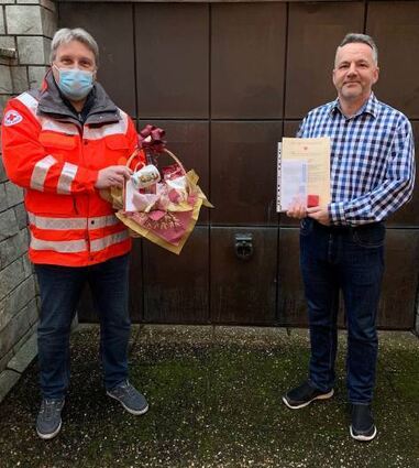 Fabrice Kühnhenrich vom DRK (l.) über-gibt Stefan Barth (r.) die Auszeichnung für die meisten Blutspenden im letzten Jahr sowie einen Präsentkorb.