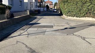 Dieser Blick in den Heiligenhag zeigt deutlich, dass die Gemeindestraßen an vielen Stellen wegen der häufigen Bauarbeiten ausgebessert worden sind – entstanden ist dadurch ein Flickenteppich.
