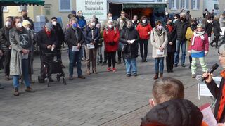 Zur Mahnwache für den Frieden versammeln sich rund 150 Menschen auf den Kleinen Planken vor der evangelischen Stadtkirche. Diakonin Margit Rothe (am Mikro) spricht, hinter ihr: Pastor Matthias Störmer.