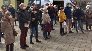 Zur besten Marktzeit am Samstagmittag halten Menschen inne und lauschen den Worten, die sich gegen den Krieg zwischen Russland und der Ukraine richten.