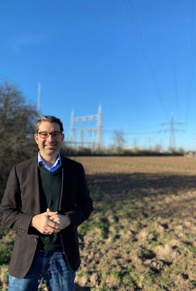 Dr. Andre Baumann vor der Bestandsstromtrasse. Der Landtagsabgeordnete spricht sich gegen einen Ersatzneubau aus.