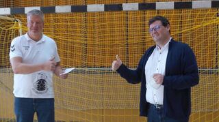 Stephan Verclas (links), Vorsitzender der Handballabteilung, übergibt einen Umschlag mit dem Spendengeld an Bürgermeister Nils Drescher.