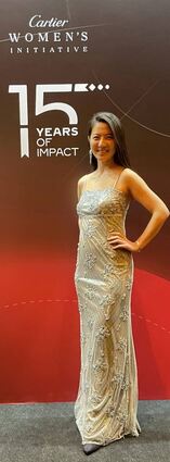 Weihua Wang posiert vor der Wand der Cartier Women’s Initiative.