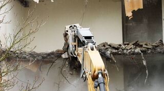 „Bissiger“ Bagger: Vom Wasserstrahl gegen die Staubverbreitung begleitet, knabbert sich das hydraulische Werkzeug durch eine Decke des Altenheims.