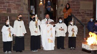 Gemeindereferent Thorsten Gut segnet das Osterfeuer und die Osterkerze vor der Kirche St. Wendelinus.