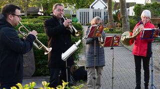 Der Posaunenchor samt Bürgermeister Jürgen Kappenstein (2. v. l.) spielt auf dem Friedhof.