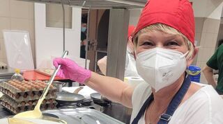 Die italienischen Gäste des Spargelfestes in Mezzago sind begeistert. Über den Spargelpfannkuchen serviert Ingrid Müller leckere Sauce Hollandaise.
