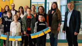Die ukrainischen Schüler mit ihren Familien werden an der Schillerschule von Rektor Falk Freise (re.) im Namen der Einrichtung begrüßt.