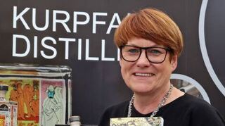 Irmgard Weis mit dem Gin „Achse“ und dem Buch „Kurpfalzachse“.