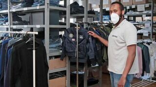 Ismail Mohamed hat in der Kleiderkammer alles im Griff. Die Kleider sind nach Größen und Geschlecht sortiert.