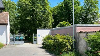 Das rosa Haus der Familie Wagner (rechts) grenzt an den Friedhof, der als Epizentrum der Ameisenplage in der Enderlegemeinde gilt. Links sind die St.-Anna-Kapelle und der Eingang zum Friedhof zu sehen.