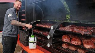 Ein heißer Job beim Street-Food-Festival: Aji besprüht die Barbecue Bacon Bombs, die auf mehreren Lagen garen, damit sie neu-gierigen Besuchern gereicht werden können.