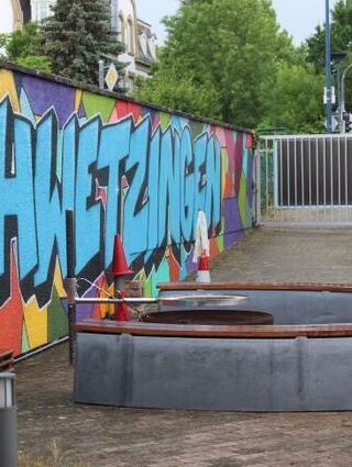 Lässiges Graffiti und ein schöner Platz laden Jugendliche ein.