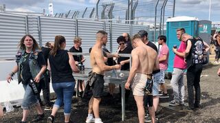 Die Besucher füllen an den Wasserständen ihre Becher auf.