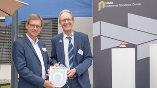 Bürgermeister Dr. Ralf Göck (r.) überreicht Gesellschafter Steffen Philipp das Gemeindewappen zur Einweihung des Costumer Solution Centers.