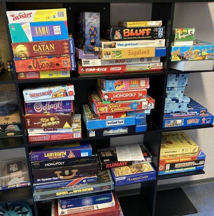 Spielesammlung gegenüber der netten Küchenzeile und der Theke: Spiel des Wissens, Monopoly, Tipp-Kick, Labyrinth und Co. – hier wird jeder Brettspielfan fündig.