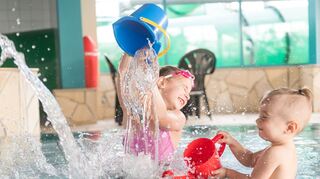 Beim Planschen lernen Kinder spielerisch den Umgang mit Wasser.