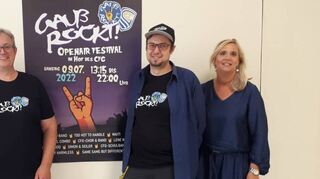 Freuen sich auf die Premiere von „Gauß rockt“: Elternbeiratsvorsitzender Kai Staecker (v. l.), die Lehrer Sascha Birkenstock und Markus Kaul sowie Direktorin Anja Kaiser vorm Plakat mit der markanten „Pommesgabel“-Hand.