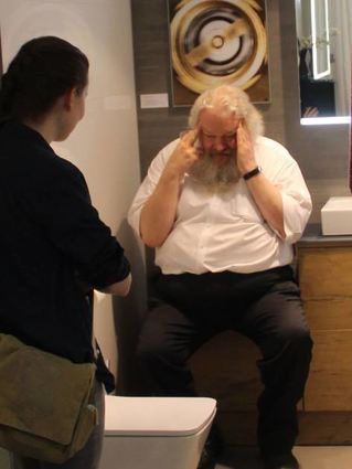 Schauspieler Dirk Schlinke performt in einem der ausgestellten Bäder.