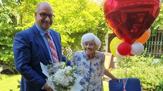 Überbringer der Glückwünsche und eines Blumenstraußes: Bürgermeister Jens Geiß mit der Jubilarin Erica Biajolan. Die ehemalige Angestellte des Hessischen Rundfunks interessiert sich unverändert für alle wichtigen aktuellen Themen.