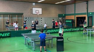 Die Mentoren der „KinderHelden“ und die Kinder beim Tischtennis-Schnuppertraining in der Schulturnhalle: Sie werden von den Aktiven des TTC unter anderem im Vor- und Rückhandspiel angeleitet.
