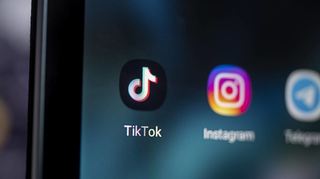 Auf dem Bildschirm eines Smartphones ist das Logo der App Tiktok (l.) zu sehen. Die Plattform hat Hunderte Millionen Nutzer auf der ganzen Welt.