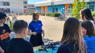 Antonella Menrath erklärt Schülern die Montage von Rohren.