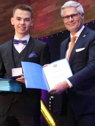 Philipp Traschütz wird von Bürgermeister Matthias Steffan für das beste Abitur geehrt.