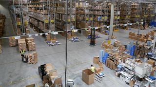 Blick von der Galerie auf eines der drei Hallensegmente: In verschiedenen Bereichen arbeiten autonome Roboter, fahren Mitarbeiter auf Tretrollern und Gabelstaplern durch Hochregale und werden Produkte auf bis zu minus 80 Grad gekühlt.