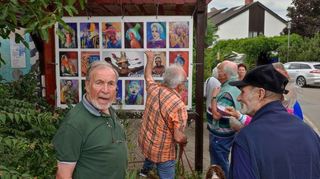 Besucher der Vernissage betrachten im Außenbereich der Galerie Strobel die Porträts verschiedener Menschen, die Wolfram Gothe geschaffen hat.