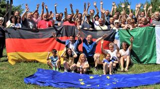 Die Mitglieder der Gemellaggio posieren zum Abschluss samt deutscher, italienischer und Europaflagge für ein Gruppenbild.
