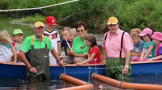 Mit allen Wasser gewaschen: Weisbrod nimmt die Regattaschiffchen des Obst- und Gartenbauvereins im Kraichbach in Empfang.