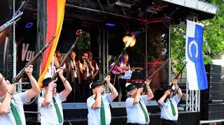 Die Salutschützen der Sportgemeinde geben zusammen mit den Kerweborscht auf der Bühne den Startschuss für das 20. Rohrhofer Sommerfest, das einen Besucheransturm wie nie zuvor erlebt. Teilweise ist vor der Zentralbühne kein Durchkommen möglich.