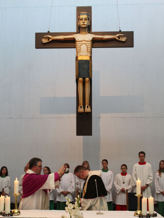Unter dem Kreuz segnet Generalvikar Christoph Neubrand (l.) Uwe Lüttinger für seinen Dienst als Dekan und macht so die Botschaft des Evangeliums deutlich: Gott ist bei dir und begleitet dich auf deinen Wegen.