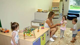 Kindergartenleiterin Nicol Lenz spielt mit dem freundlichen Trio in einem der praktisch und warm eingerichteten Gruppenräume.