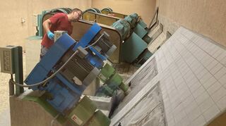 Ein Mitarbeiter kontrolliert eine der fünf Pumpen im Hebewerk. Vorne die beiden kleineren Anlagen für trockenes Wetter, hinten die für Regenwetter, die jeweils eine Pumpenschnecke von rund 1,6 Metern Durchmesser betreiben.