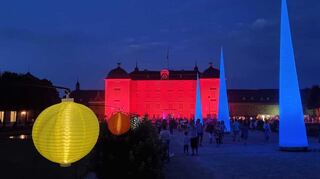 Das Schloss ist schön illuminiert. Große Pylone und kleine bunte Solar-Lampions in den Beeten leuchten am Abend.