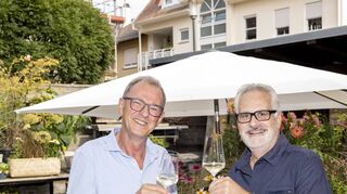 Der ehemalige Leiter der Volkshochschule Speyer Ewald Gaden und der ehemalige Banker und jetzige Autor Uwe Ittensohn (r.), absolvierten erfolgreich die einjährige Ausbildung zum „Kultur- und Weinbotschafter Pfalz“ des Dienstleistungszentrums Länd-licher Raum Neustadt und erhielten im Juni 2022 ihre Zertifikate. Auf diesen Erfolg stoßen sie in der Weinlounge Berzelhof in Speyer mit einem Glas Wein an.
