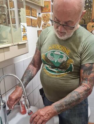 Händler Dieter Ochs beim Befüllen einer Trinkwasserflasche.