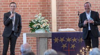 In der Christuskirche, in der sich Dr. Simon Layer (l.) im April bei seiner Vorstellung den Fragen des Vorsitzenden der Gemeindeversammlung, Bernd Kappenstein, stellt, hält der neue Pfarrer nun seinen ersten Gottesdienst.