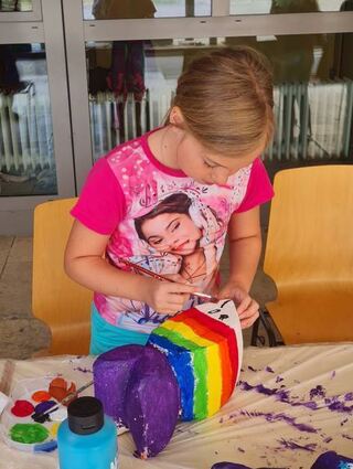 Charlotte aus Mannheim kreiert einen bunten Regenbogenfisch.