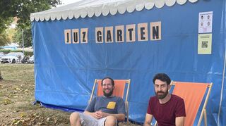 Jens Petri (l.) und Emanuel Kuderna von der Mobilen Jugendarbeit Postillion im Juz-Garten beim Ketscher Backfischfest. Hier, im grünen Dreieck vor der Rheinhalle, ist erstmalig ein Anlaufpunkt für Jugendliche während des Festes entstanden.