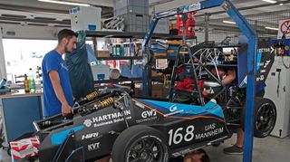 Es gibt immer etwas zu verbessern: Fabian Lätzsch (v. l.), Thomas Uth (unterm Fahrzeug) und Paul Hofmann vom Team Delta Racing der Hochschule Mannheim arbeiten in der Box.