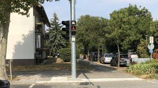 „Bitte warten“ steht über dem roten Ampelmännchen sobald man ein Grün für Radler und Fußgänger per Knopfdruck anfordert.