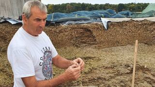 Heinrich Schuhmacher zeigt den getrockneten Mais, den er an sein Vieh verfüttert