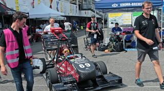 In der Formula Student auf dem Hockenheimring fahren die Teammitglieder von CURE, Marek Milker (v. l.), Nils Starbaty und Anne Lederer ihren Fahrer Matteo Schäfer gemeinsam mit Johannes Neuhaus auf die Rennstrecke. Der in Eppelheim gebaute E-Rennwagen „Emma“ wird als Teil des Studiengangs Projekt Engineering an der Dualen Hochschule entwickelt.