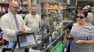 Oftersheims Bürgermeister Jens Geiß (v. l.) kassiert unter den gestrengen Augen von Edeka-Chef Oliver Embach die Kundin Waltraud Schlamm ab.