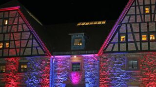 Die Zehntscheune ist bei der HoNaMu erneut Spielstätte und wird, wie schon vor der Corona-bedingten Zwangspause, in den Farben der Veranstaltung illuminiert.