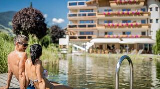 Sonnenbaden am Bio-Schwimmteich – einfach herrlich! Nach Saunagängen bietet das kühle Nass die perfekte Abkühlung.